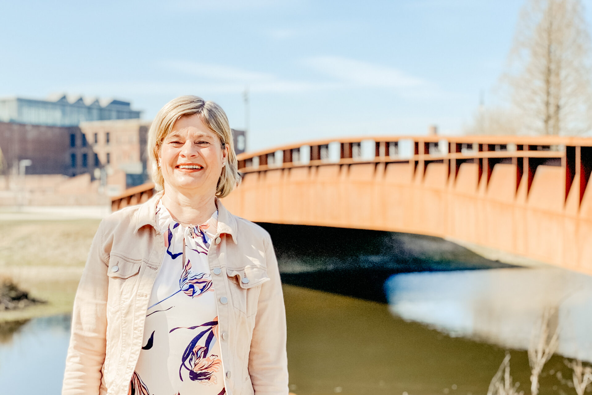 Portrait von Mitarbeiterin Renate vor der Brücke